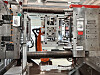 Nærbilde av industriell sprøytestøpemaskin med robotarm i moderne fabrikkhall.