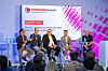 Ekspertpanel på scenen under embedded world-konferansen foran et sittende publikum.